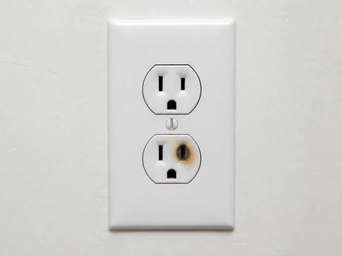 What a fault leaves behind: overheated current scorched this socket. This is the danger the fuse and the breaker exist to stop.