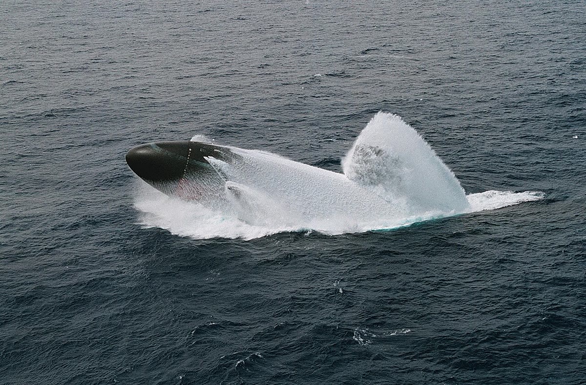 A submarine in an emergency surfacing drill (US Navy): its ballast tanks blown, it is lighter than the water it displaces and rises — Archimedes’ theorem at 7000\, t.