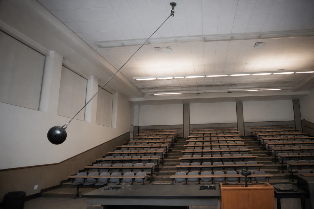 The lecturer’s pendulum: released from the nose, the bowling ball returns to the nose and no further — mechanical energy is conserved, and never exceeded.