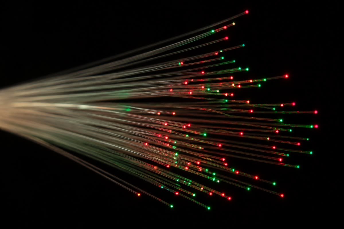 Optical fibres lit from their far ends: light trapped by total internal reflection in a core thinner than a hair, and guided round every gentle bend.