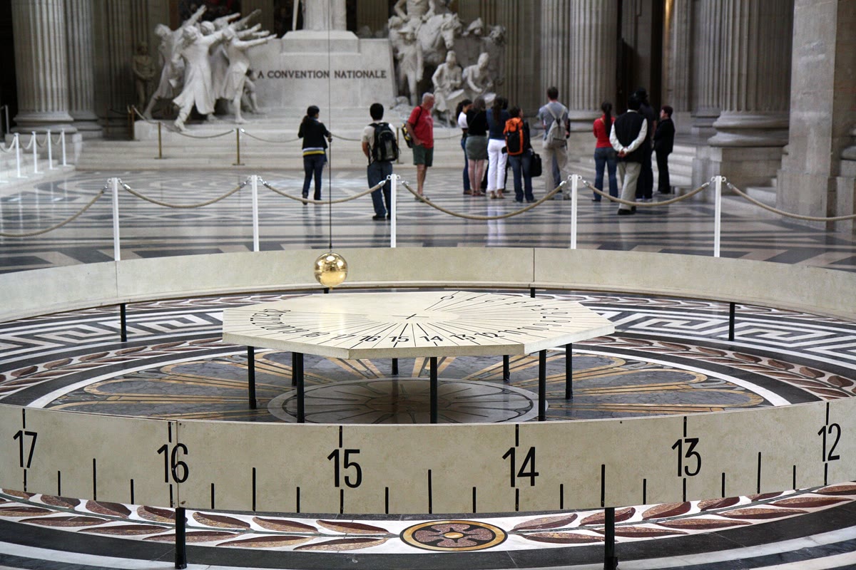 El péndulo de Foucault en el Panteón de París. Coordenadas generalizadas, una ligadura y un sistema de referencia que gira lentamente: la rotación de la sala aparece en las ecuaciones del movimiento — y la deriva del plano de oscilación permite a un sótano medir el giro de la Tierra. Fotografía: Olga Khomitsevich, CC BY 2.0.